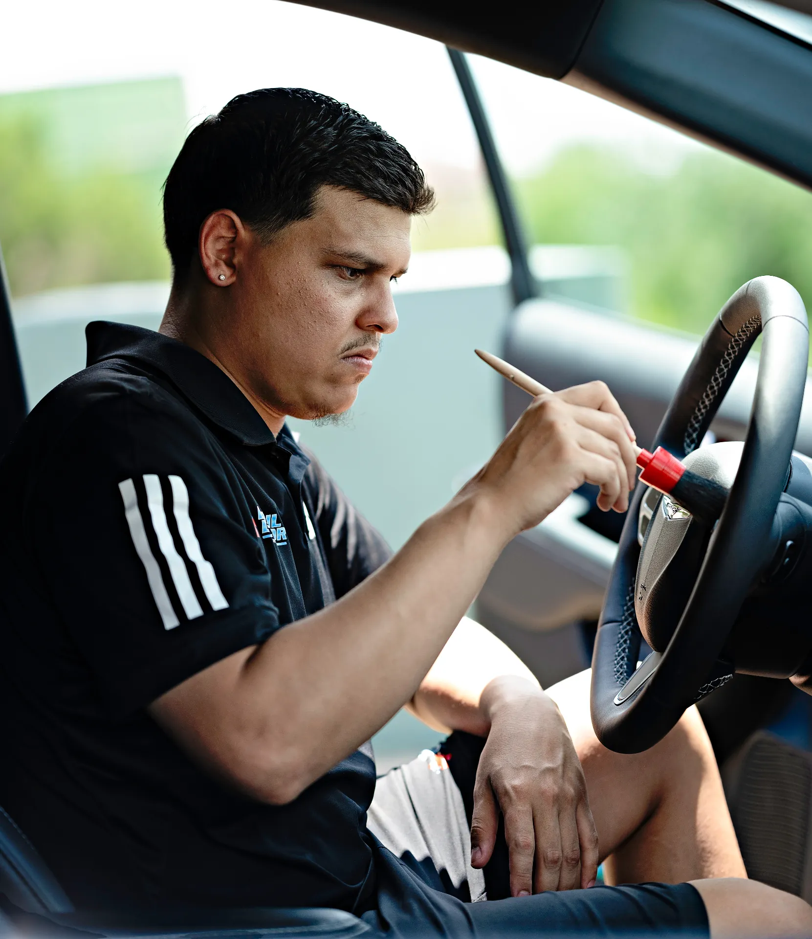 Eric detailing a steering wheel by hand with a precision brush