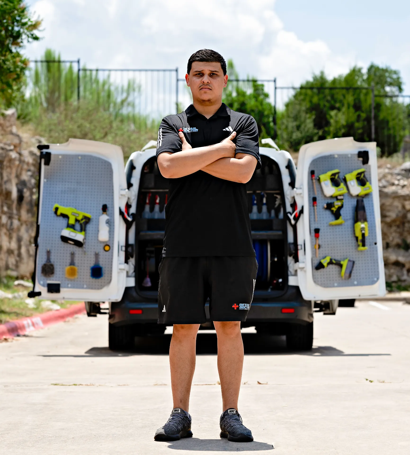 Eric standing in front of the Detail Doctor mobile van with rear doors open showing organized tools and equipment